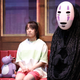 In a scene from the Spirited Away stage play, Chihiro and No Face sit on a train with Boh mouse.